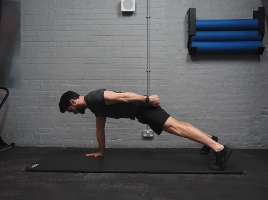 man performing single-arm high plank 