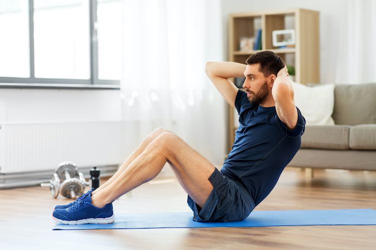 A man exercising by doing crunches at home