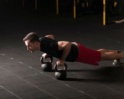 Man performing kettlebell press-up