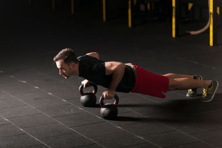 Man performing kettlebell press-up