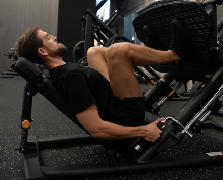 Man in a gym performing a leg press