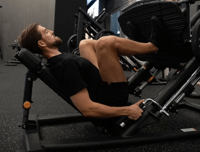 Man in a gym performing a leg press