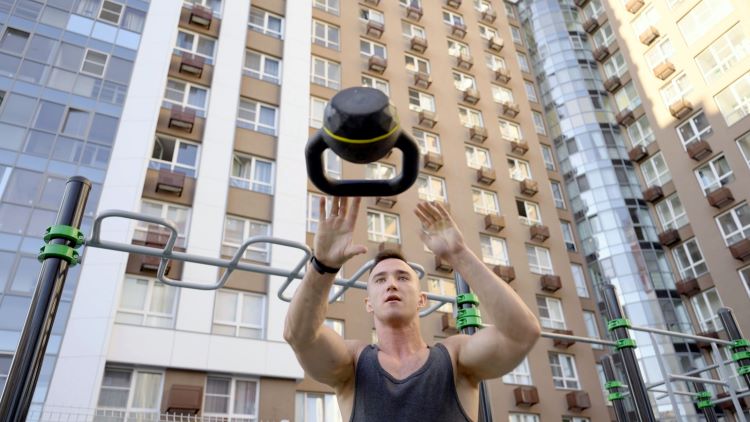 Man outside throwing a kettlebell