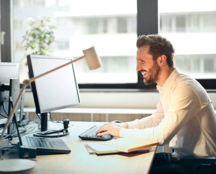 man accessing online therapy on computer for mental health