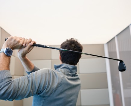 man swinging golf club while wearing a Huawei smartwatch