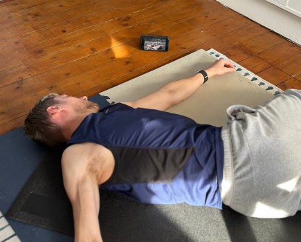 Man lying on the floor doing mobility exercises