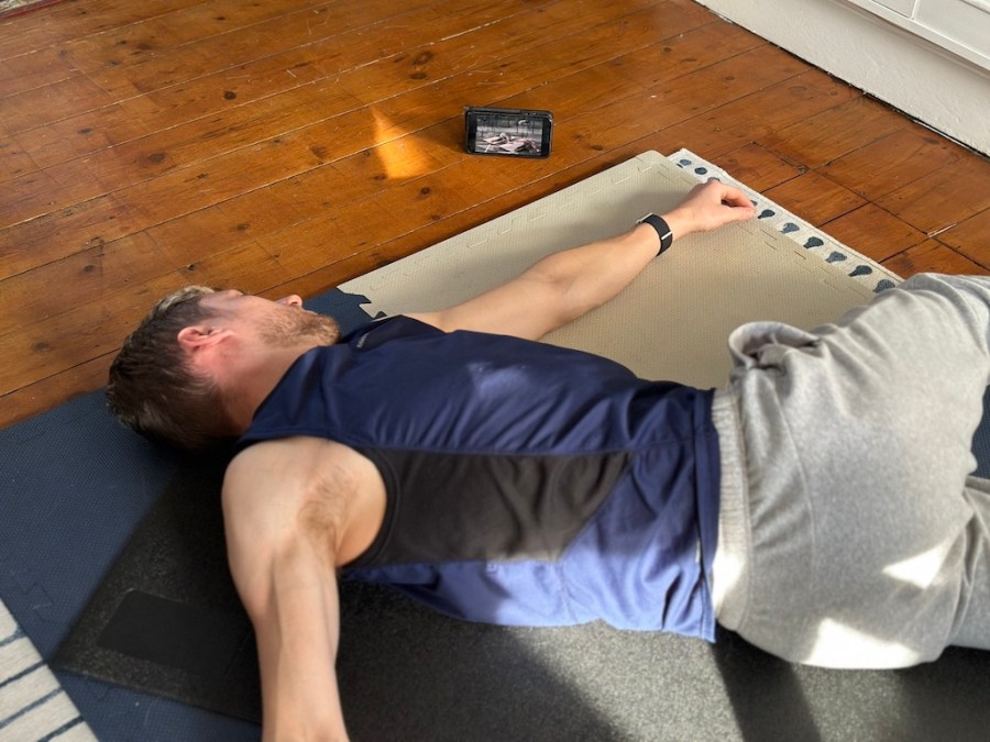 Man lying on the floor doing mobility exercises