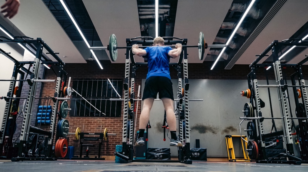 Joel Makin performs squats in the gym