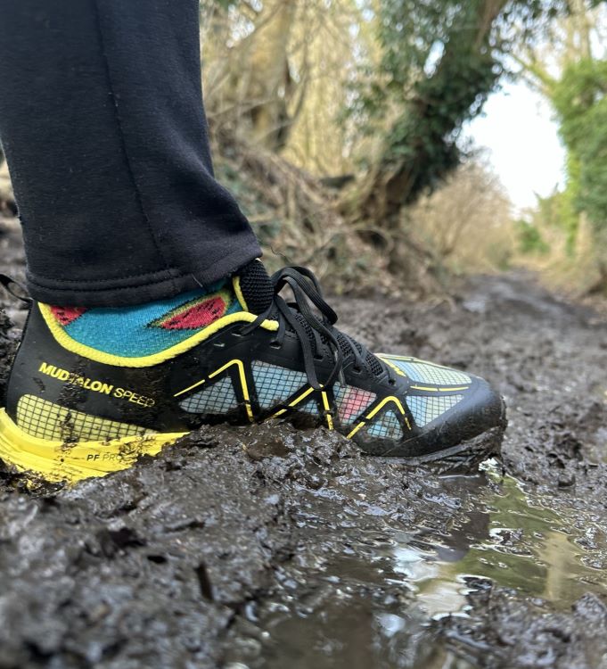 Close-up of a running shoe stepping in mud