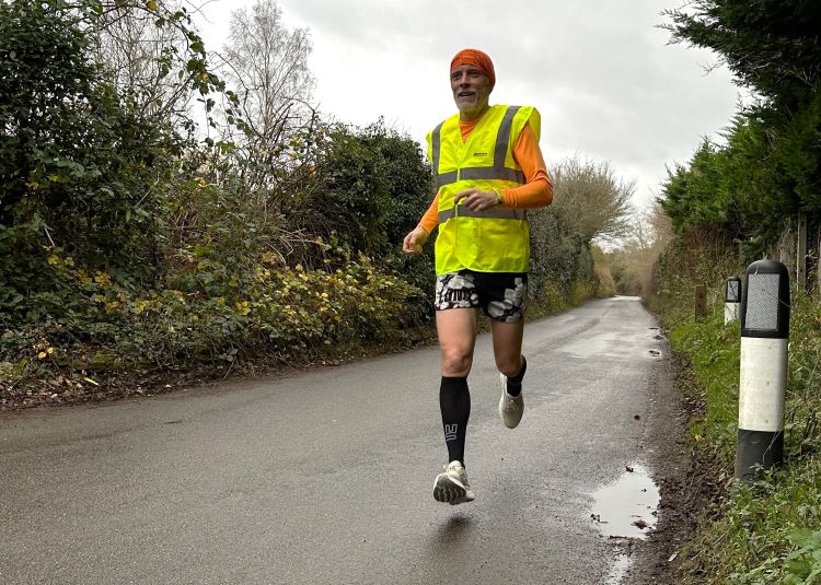 A man road running with hi-viz jacket