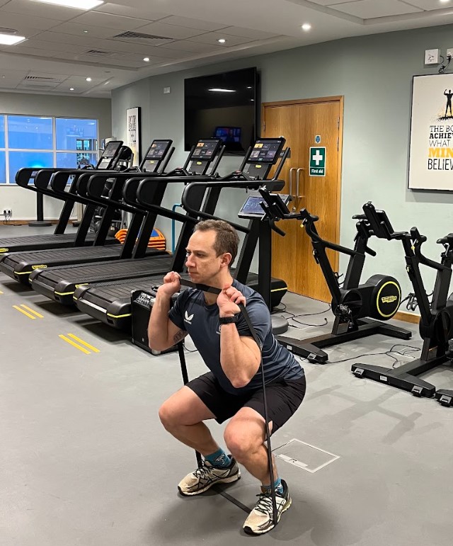 Man performing a resistance band squat press