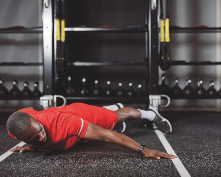 man in red top and red shorts doing a typewriter push-up