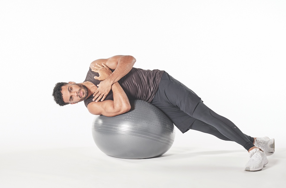 man demonstrating exercise ball oblique crunch