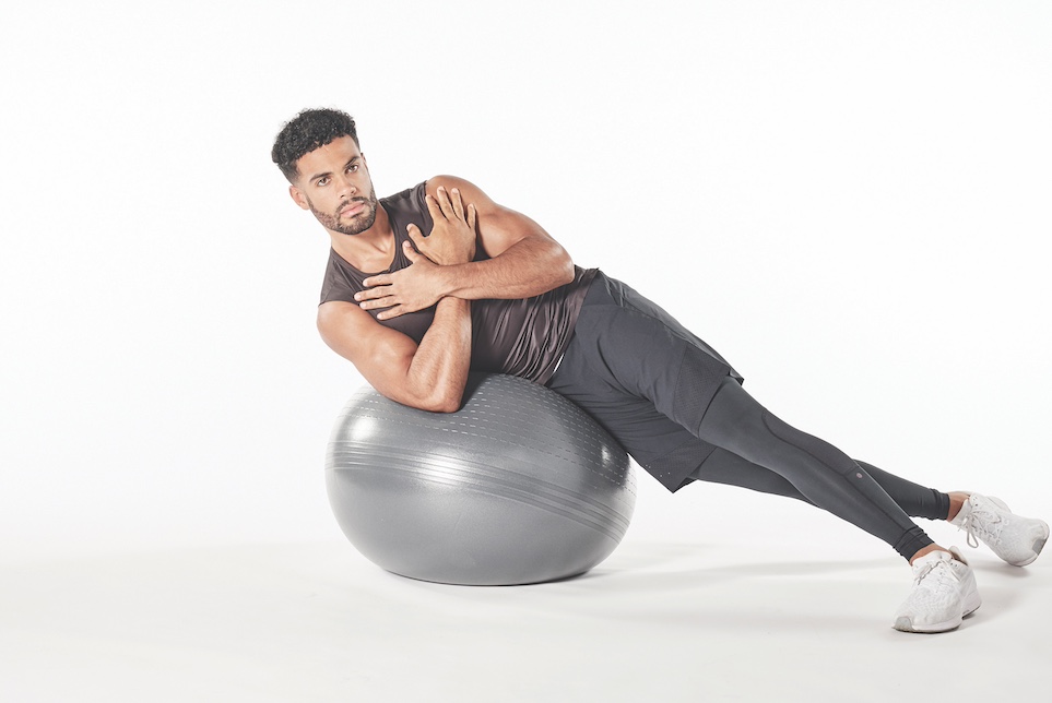 man demonstrating exercise ball oblique crunch