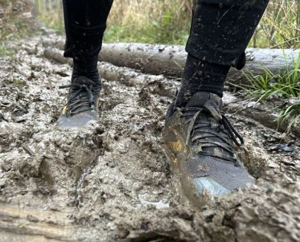 Off-road shoes sinking in a muddy trail