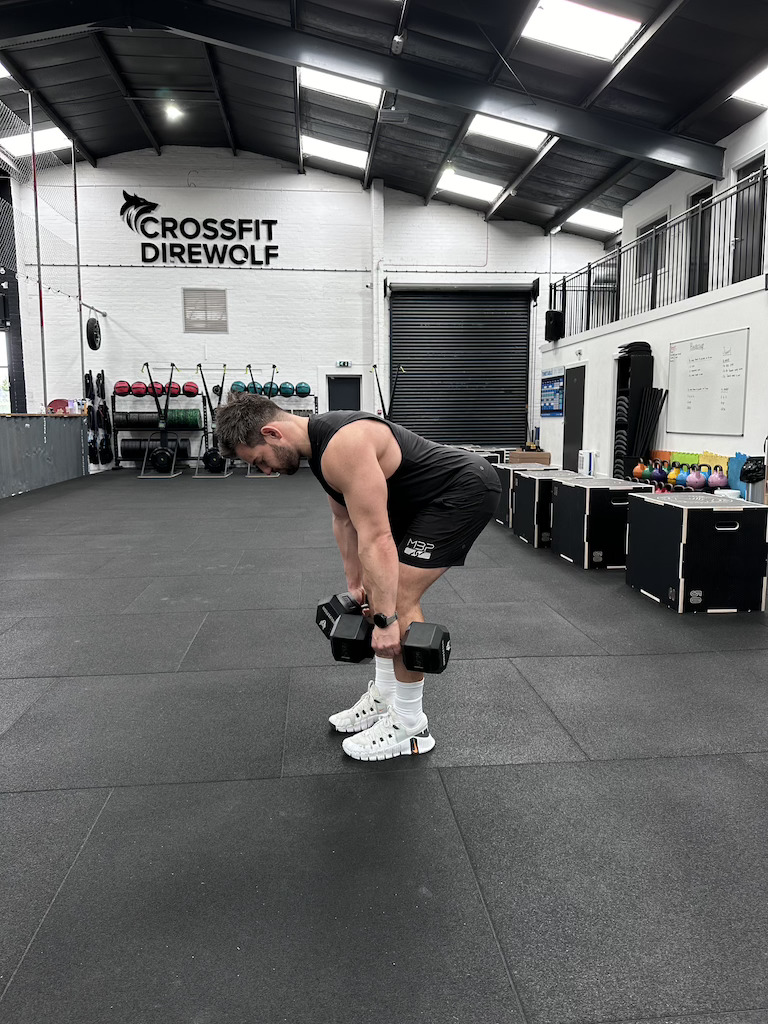 PT demonstrating how to do a dumbbell romanian deadlift as part of a dumbbell-only leg workout