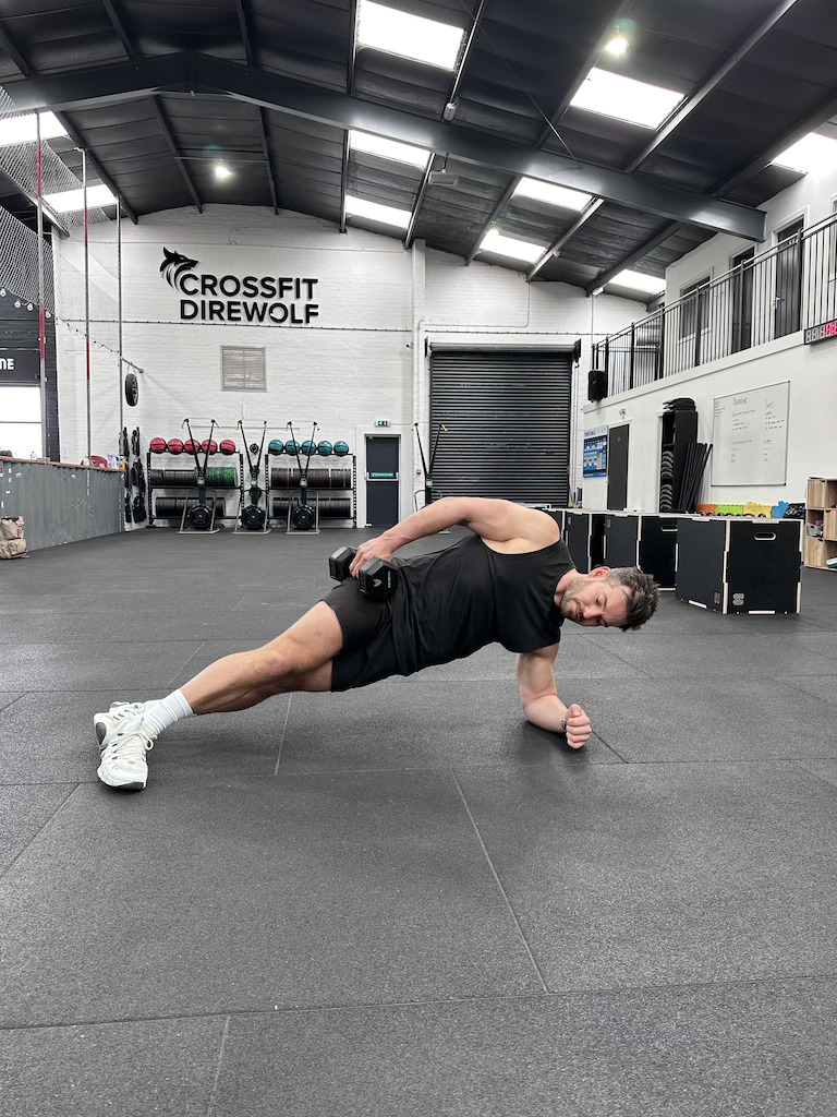 PT demonstrating weighted side plank exercise