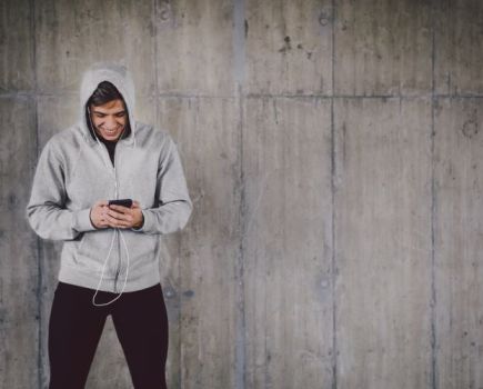 Man in a hoodie looking at his phone