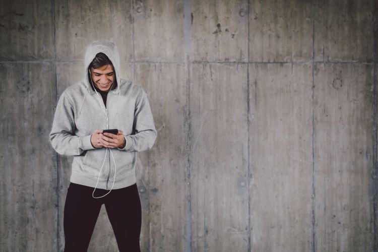 Man in a hoodie looking at his phone