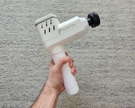 A hand holding a massage gun