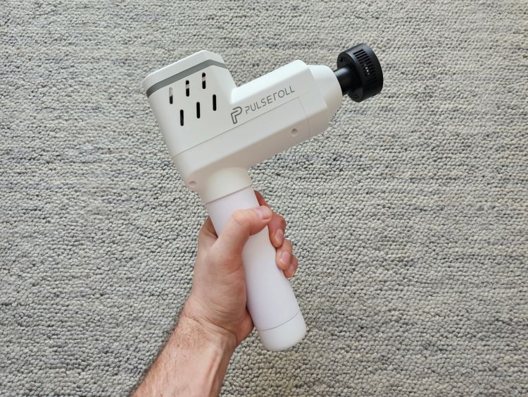 A hand holding a massage gun