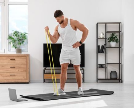 A man exercising with resistance bands at home