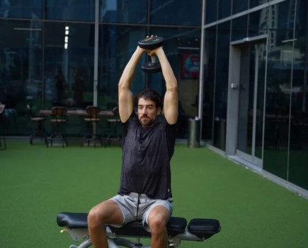 Man performing a seated triceps overhead press