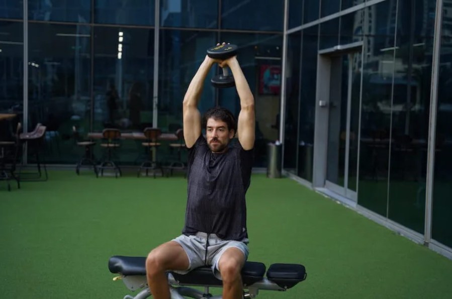 Man performing a seated triceps overhead press