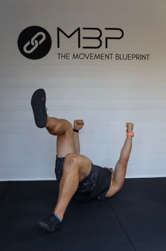 Man performing an alternating glute march exercise