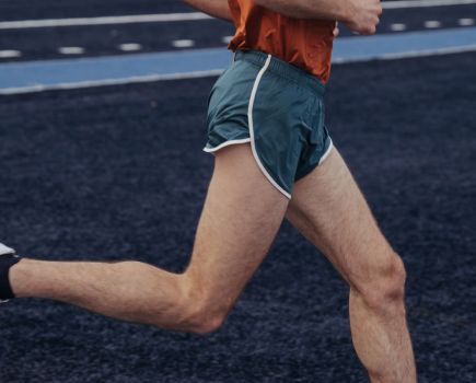 Man running while wearing the Tracksmith Twilight 3-inch split short