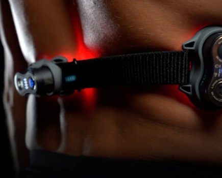 red light therapy device being used on man's back