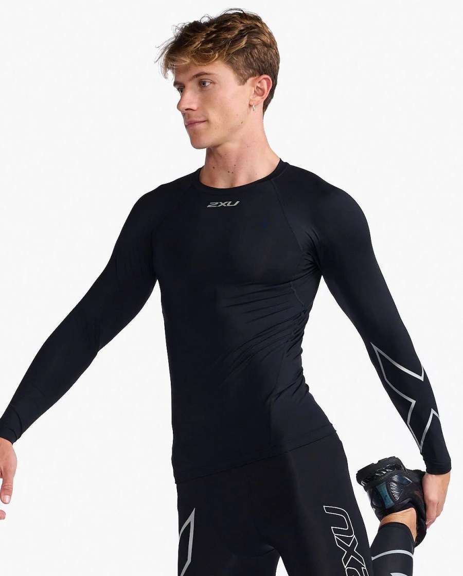 man stretching wearing 2xu compression black long-sleeve top