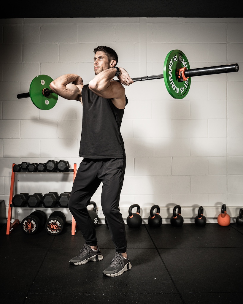 PT demonstrating how to do a barbell power clean as part of a metabolic resistance training workout