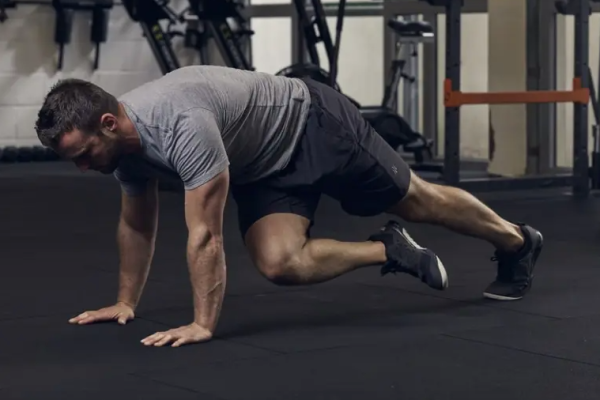 A man in the gym performing bodyweight exercises