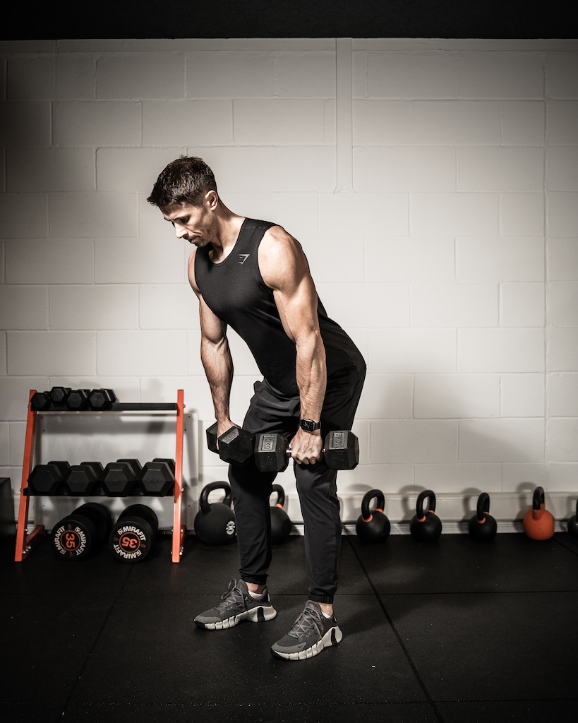 Personal trainer demonstrating how to do a dumbbell clean 