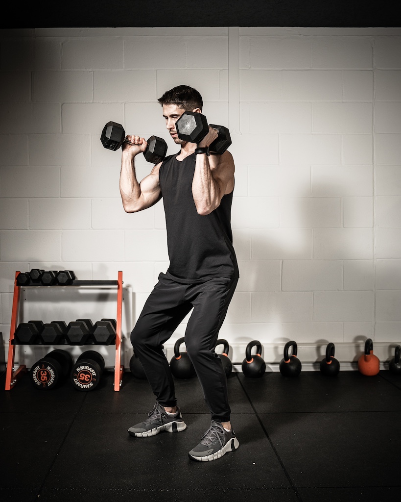 Personal trainer demonstrating how to do a dumbbell clean 