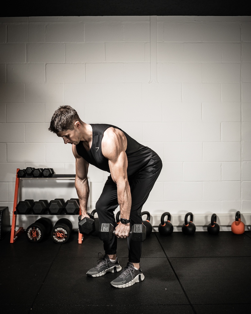 Personal trainer demonstrating how to do a dumbbell bent-over row