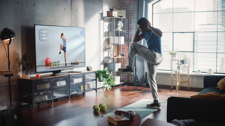 Man at home copying a workout on TV