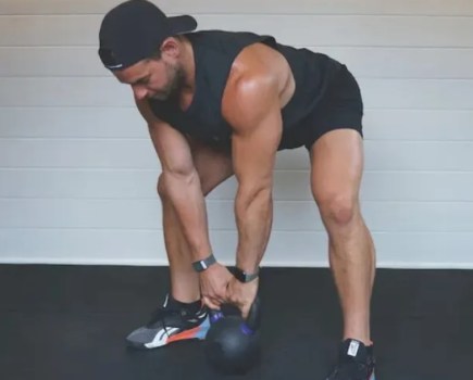 Man performing a kettlebell sumo deadlift