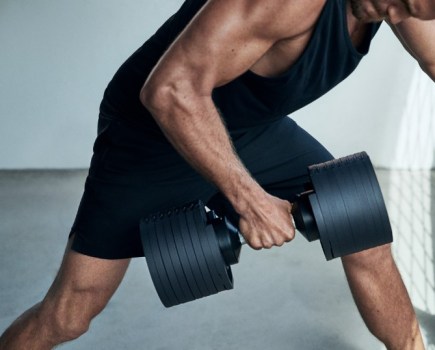 A man lifting an adjustable dumbbell