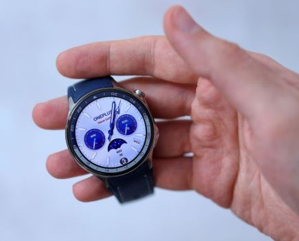 Man's hand holding a running watch