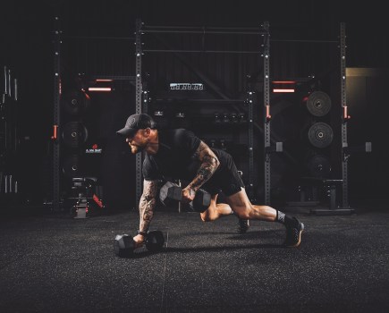 man performing dumbbell man maker exercise as part of a functional strength workout