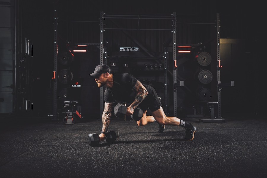 man performing dumbbell man maker exercise as part of a functional strength workout