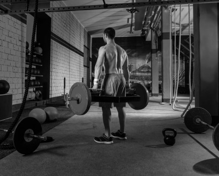 man performing hex bar deadlift as part of an American football workout