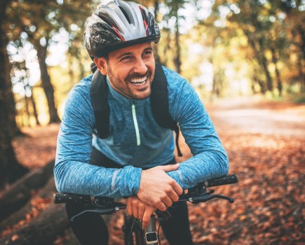 Happy male cyclist in forest