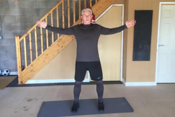 A man performing stretching exercises at home