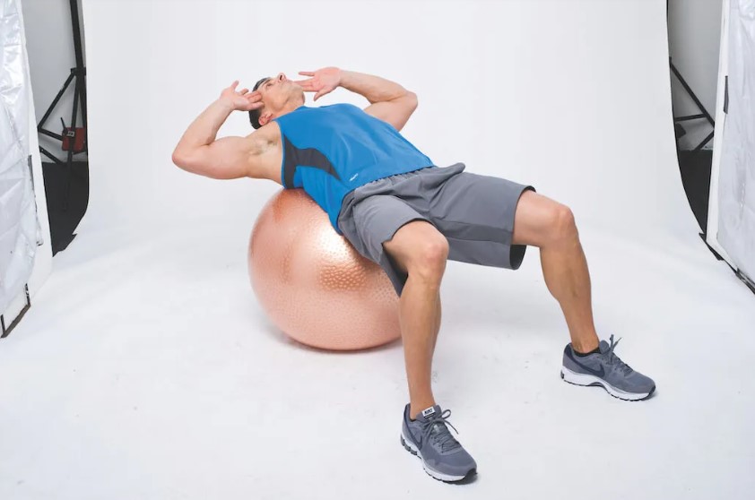 Man performing a dumbbell and gym ball abs workout