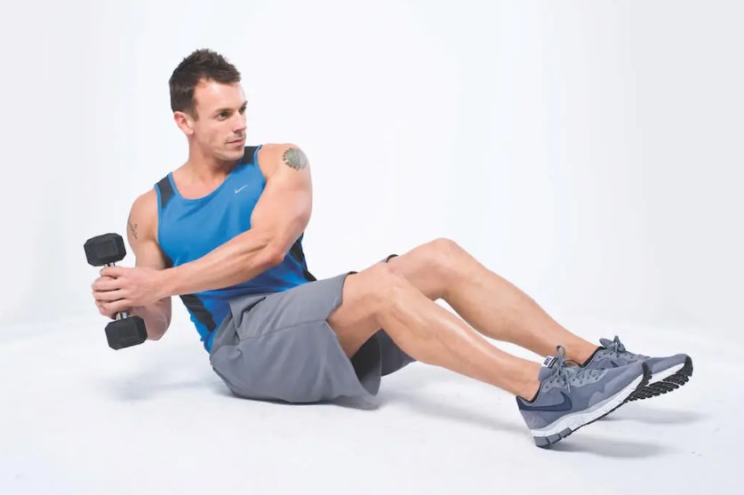 Man performing a dumbbell and gym ball abs workout