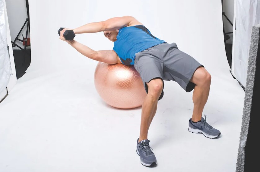 Man performing a dumbbell and gym ball abs workout