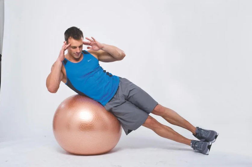 Man performing a dumbbell and gym ball abs workout